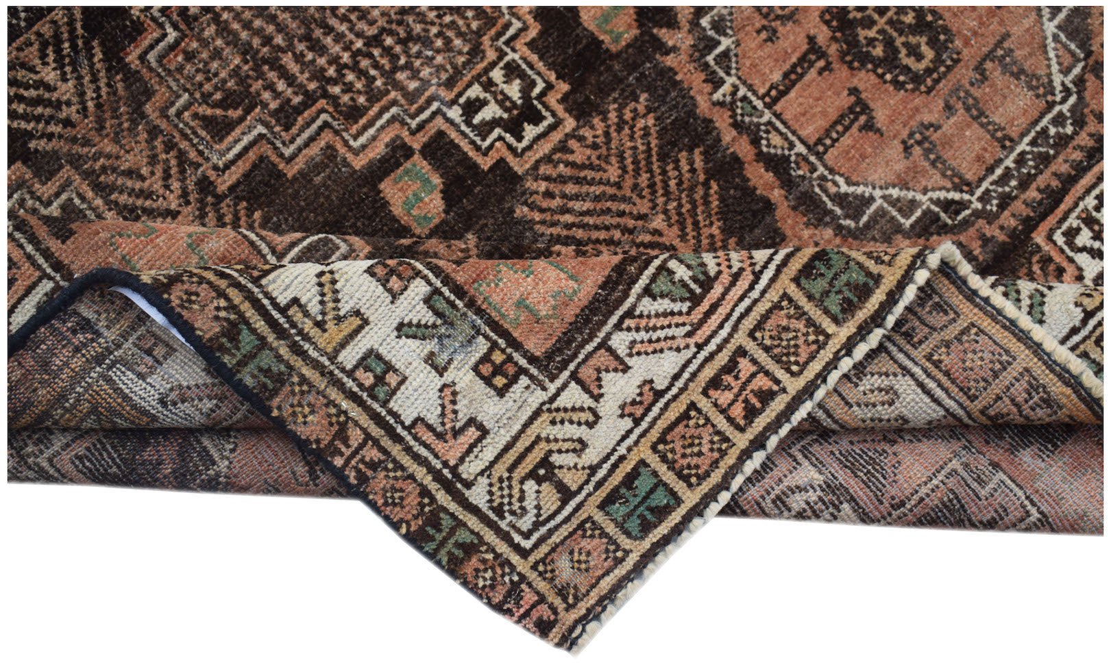 A handmade Afghan Baluch rug with geometric patterns in shades of brown, rust, and cream.
