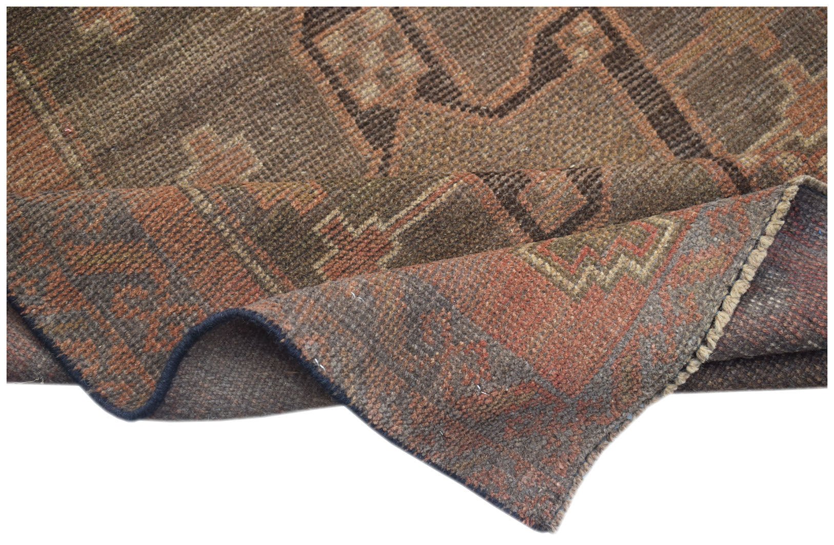 A handmade Afghan Baluch wool rug featuring geometric patterns in shades of brown and rust.