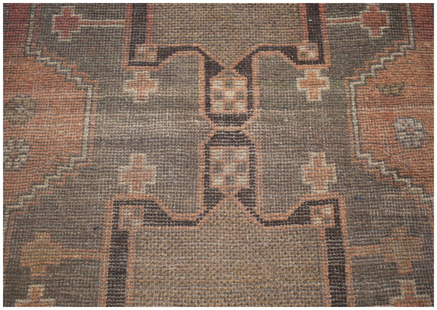 Handmade Afghan Baluch rug featuring a geometric pattern in shades of brown and terracotta.