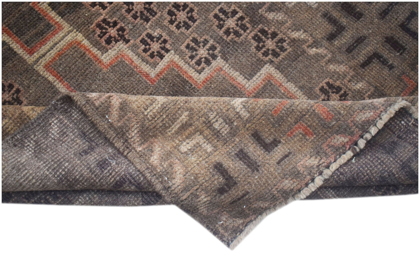 A handmade Afghan Baluch rug with a geometric pattern in brown, tan, and orange tones.