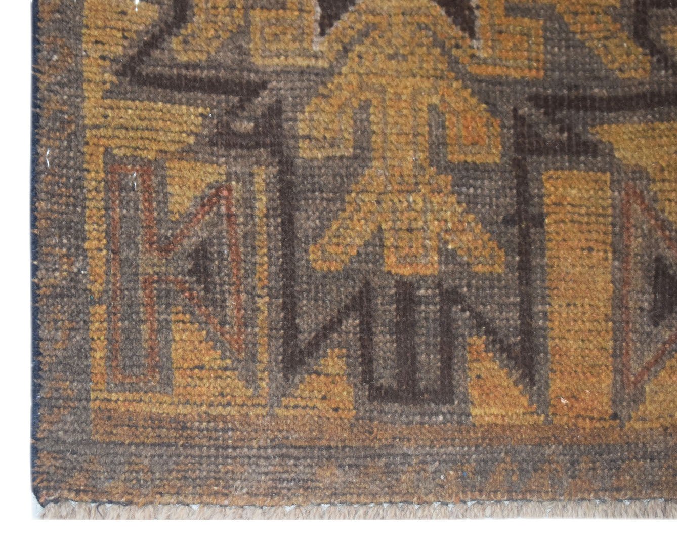 A close-up of a handmade Afghan Baluch rug featuring geometric patterns in brown and gold wool.
