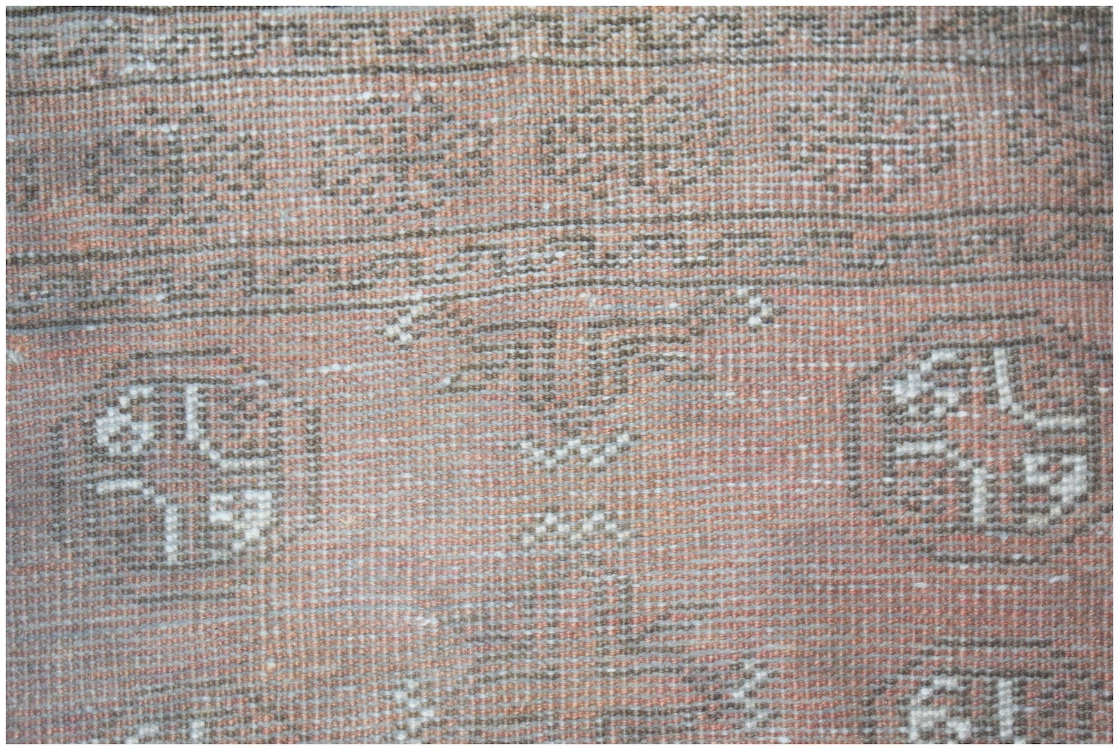 A handmade Afghan Baluch rug featuring geometric patterns in shades of red and brown.