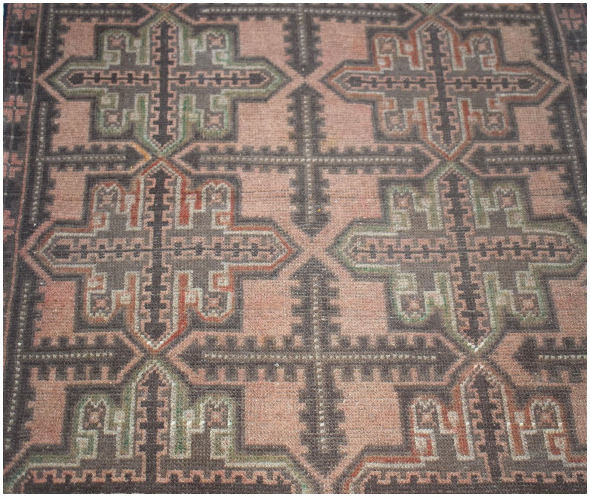 Handmade Afghan Baluch rug featuring a geometric cross pattern in muted pink, brown, and green.