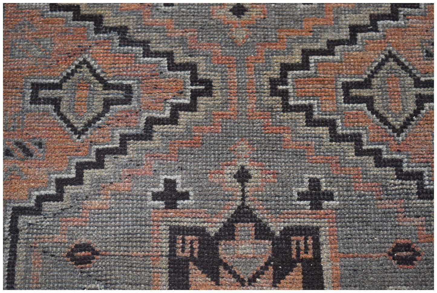 Handmade Afghan Baluch rug featuring a geometric pattern in shades of grey and terracotta.