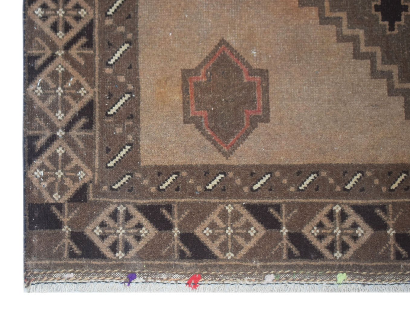 Handmade Afghan Baluch rug featuring geometric patterns in shades of brown and tan.