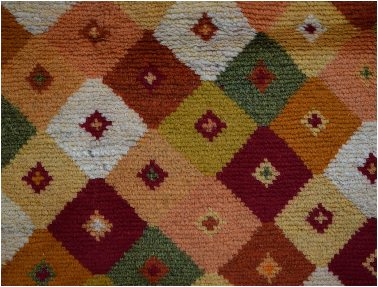 Handmade Afghan Baluch rug featuring a geometric diamond pattern in earthy tones with small accents.
