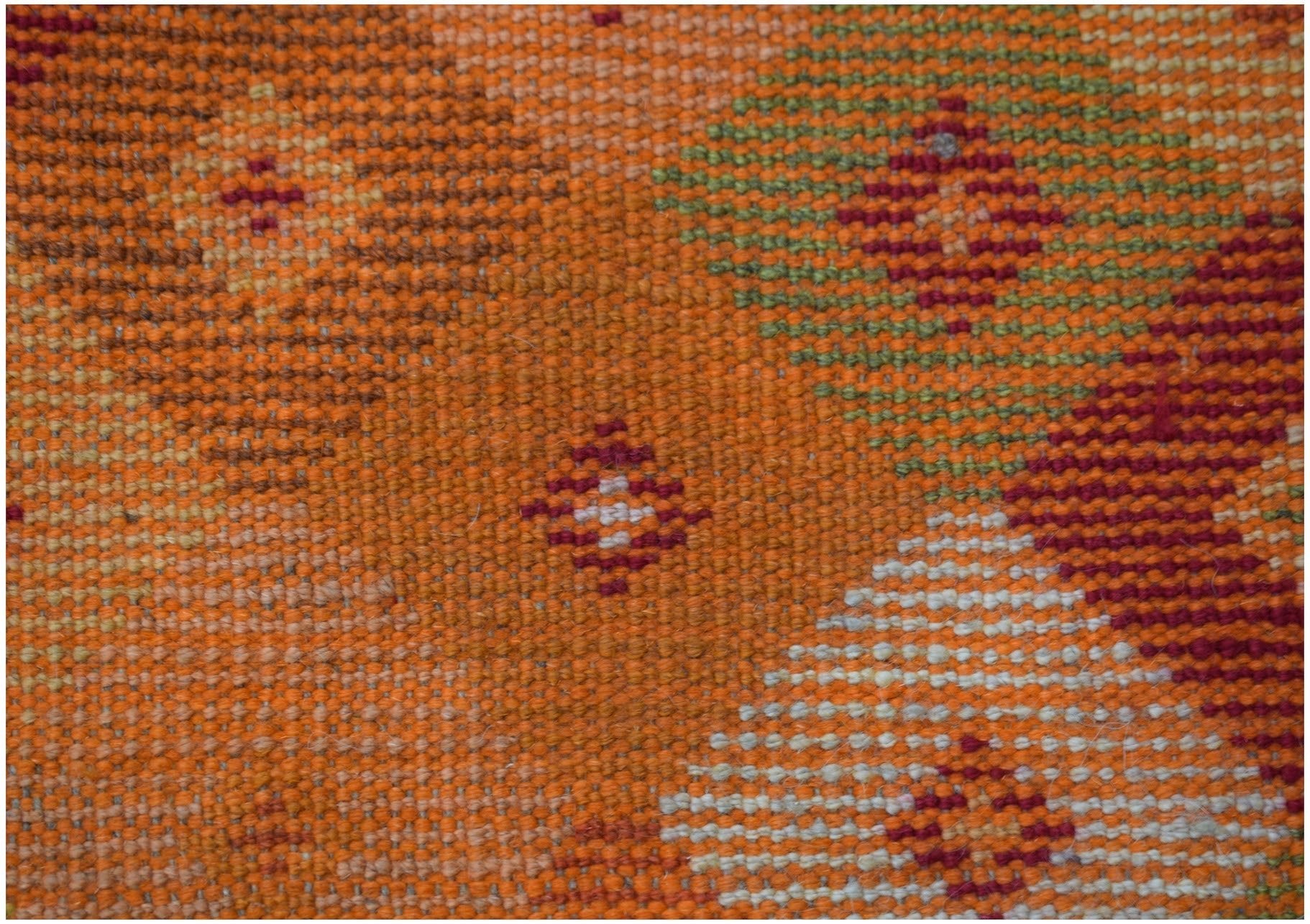 Handmade Afghan Baluch rug featuring geometric patterns in shades of orange, red, and ivory.