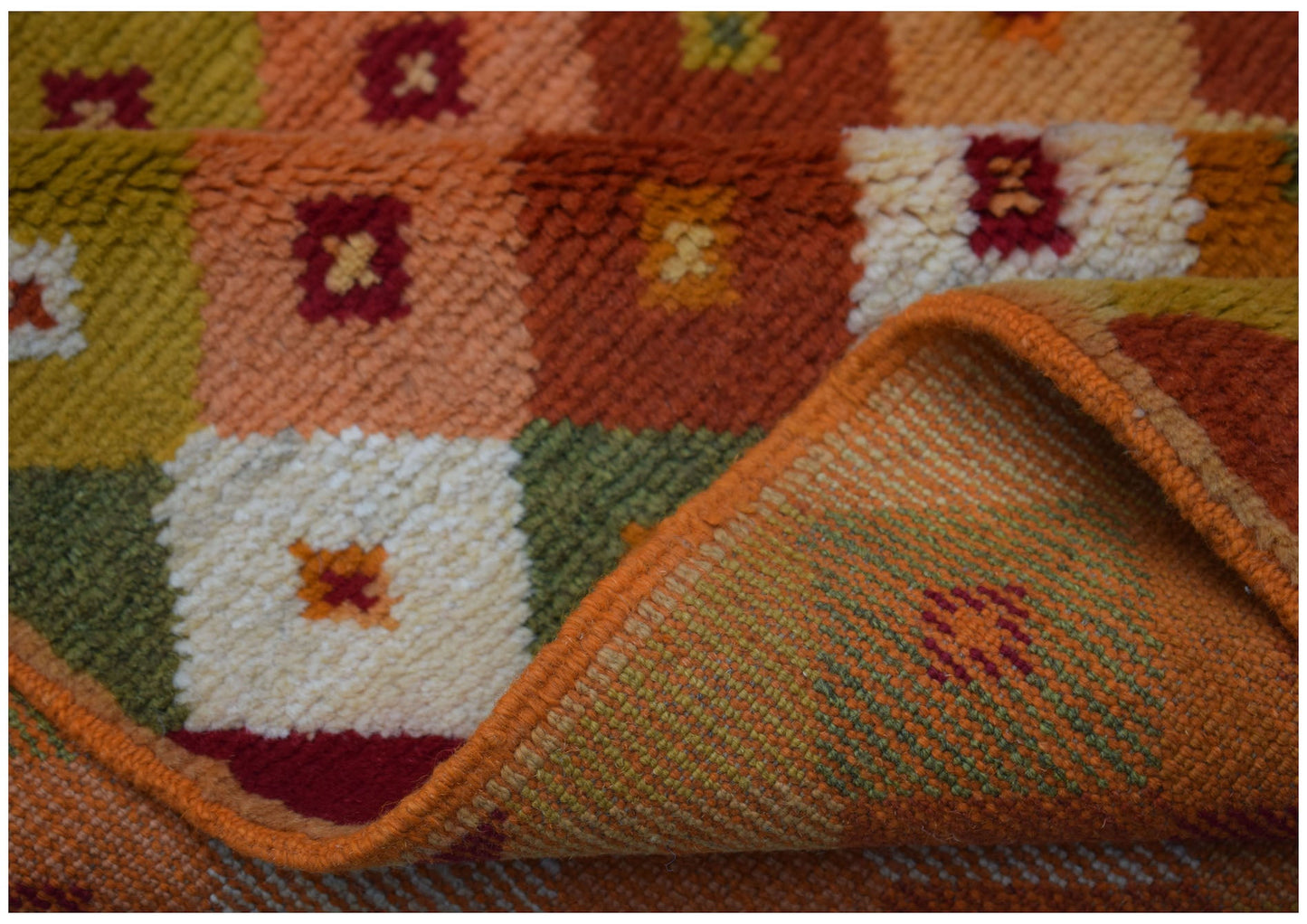 A handmade Afghan Baluch rug featuring a geometric grid pattern in warm earth tones.