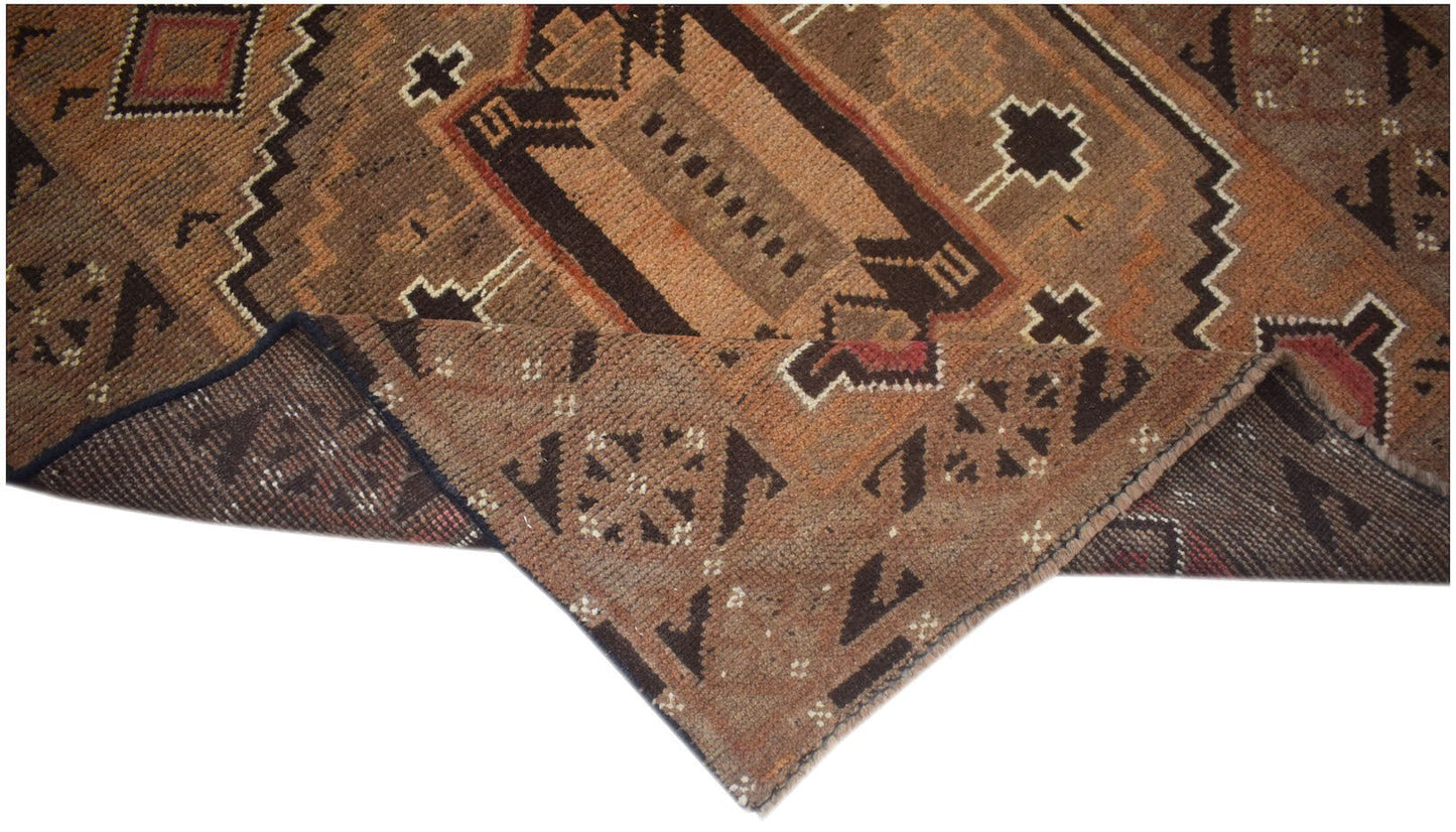 Handmade Afghan Baluch rug featuring geometric patterns in shades of brown and orange.