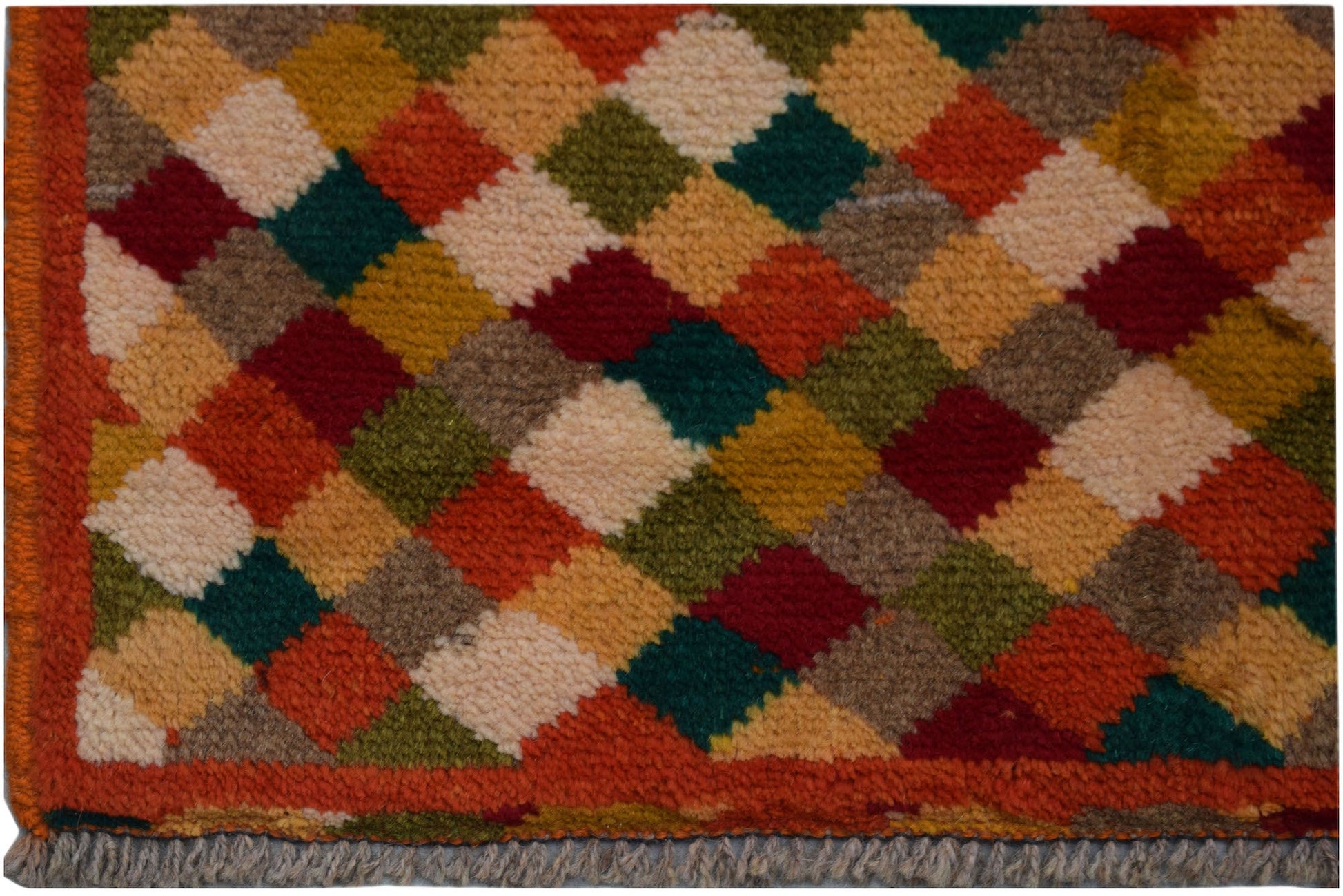 Handmade Afghan Baluch rug featuring a colorful diamond pattern and a fringed edge.
