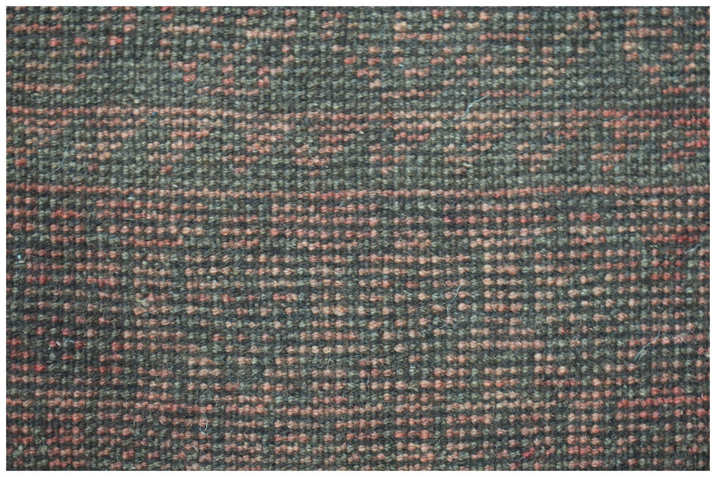 Close-up of a handmade Afghan Baluch rug featuring a textured pattern of dark brown and orange wool.