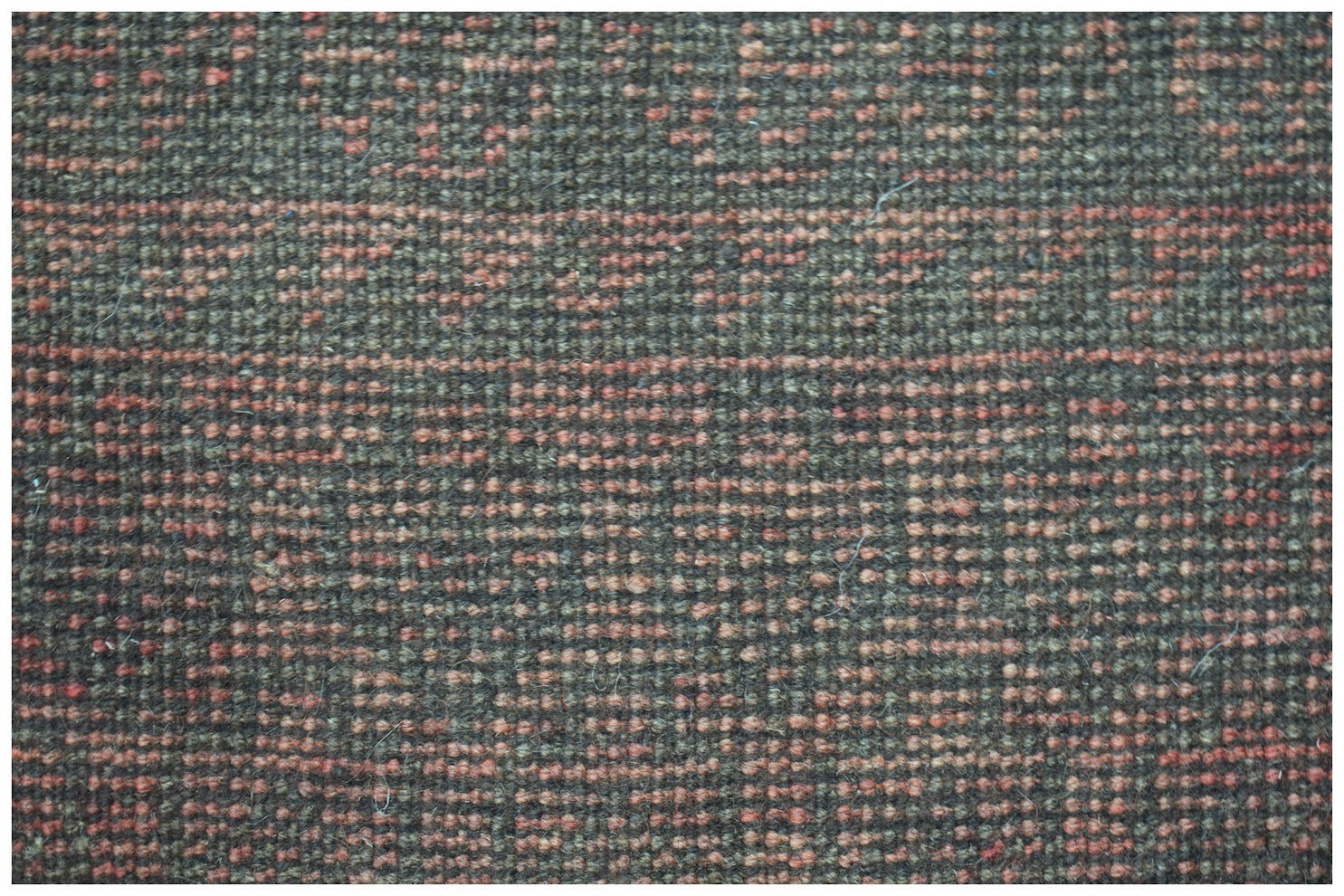 Close-up of a handmade Afghan Baluch rug featuring a textured pattern of dark brown and orange wool.