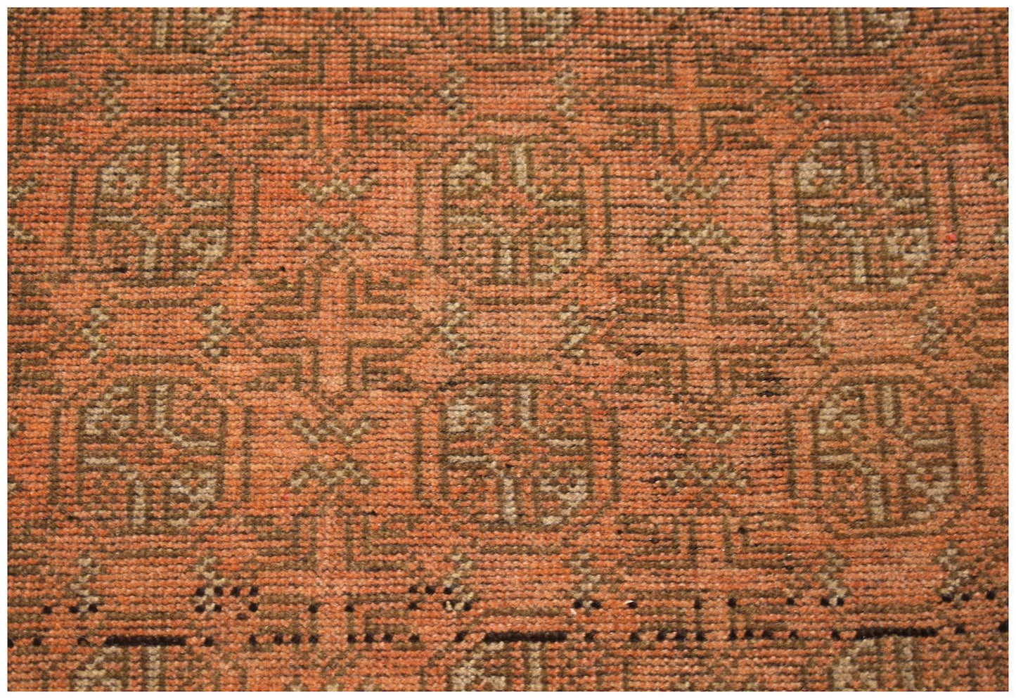 Handmade Afghan Baluch rug featuring a repeating geometric pattern in shades of orange and brown.