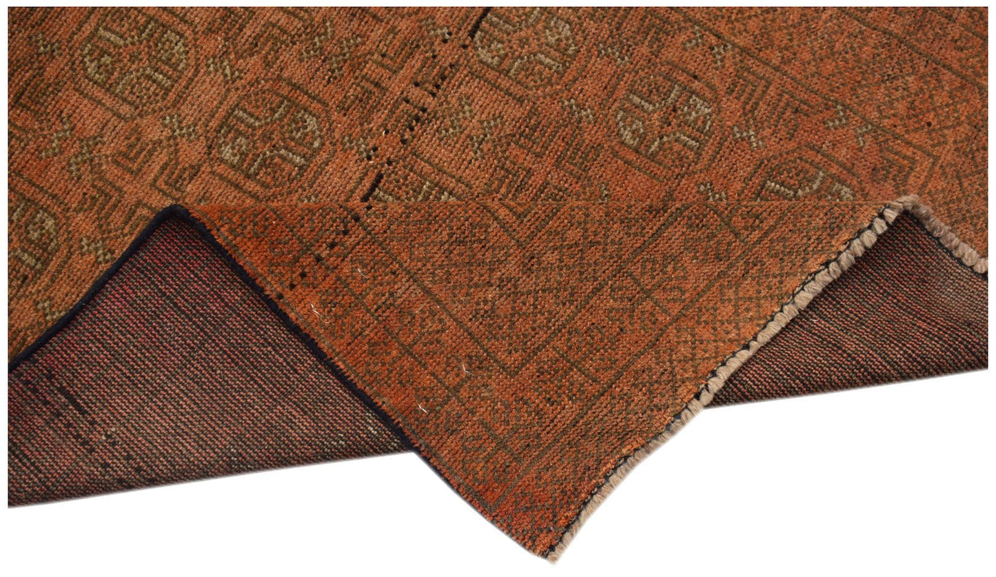 A handmade Afghan Baluch rug with a geometric pattern in shades of rust orange and brown.