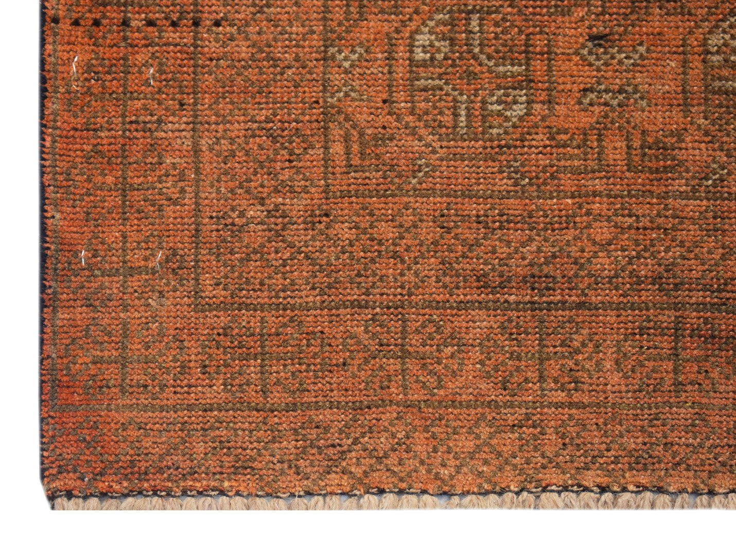 A close-up of a handmade Afghan Baluch rug featuring a geometric pattern in shades of orange.