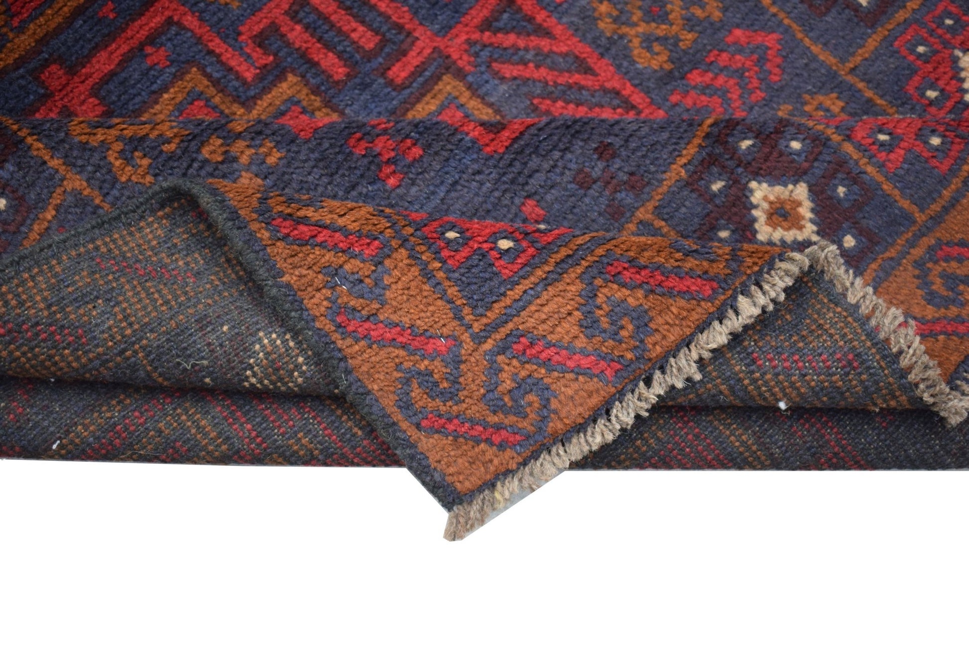 A handmade Afghan Baluch rug featuring a geometric pattern in dark red, brown, and blue tones.