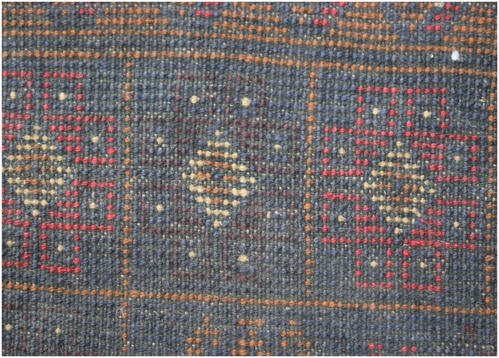 A handmade Afghan Baluch rug featuring a geometric pattern in dark red, blue, and ivory wool.