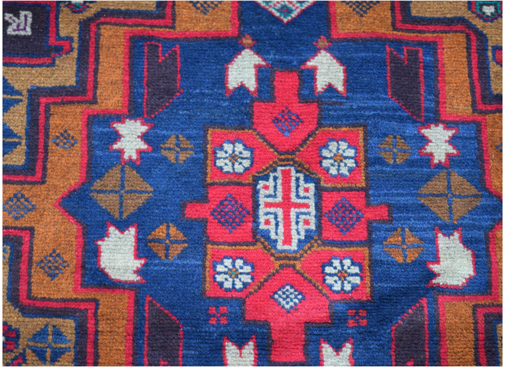 Handmade Afghan Baluch rug featuring a geometric pattern in blue, red, and ivory wool.