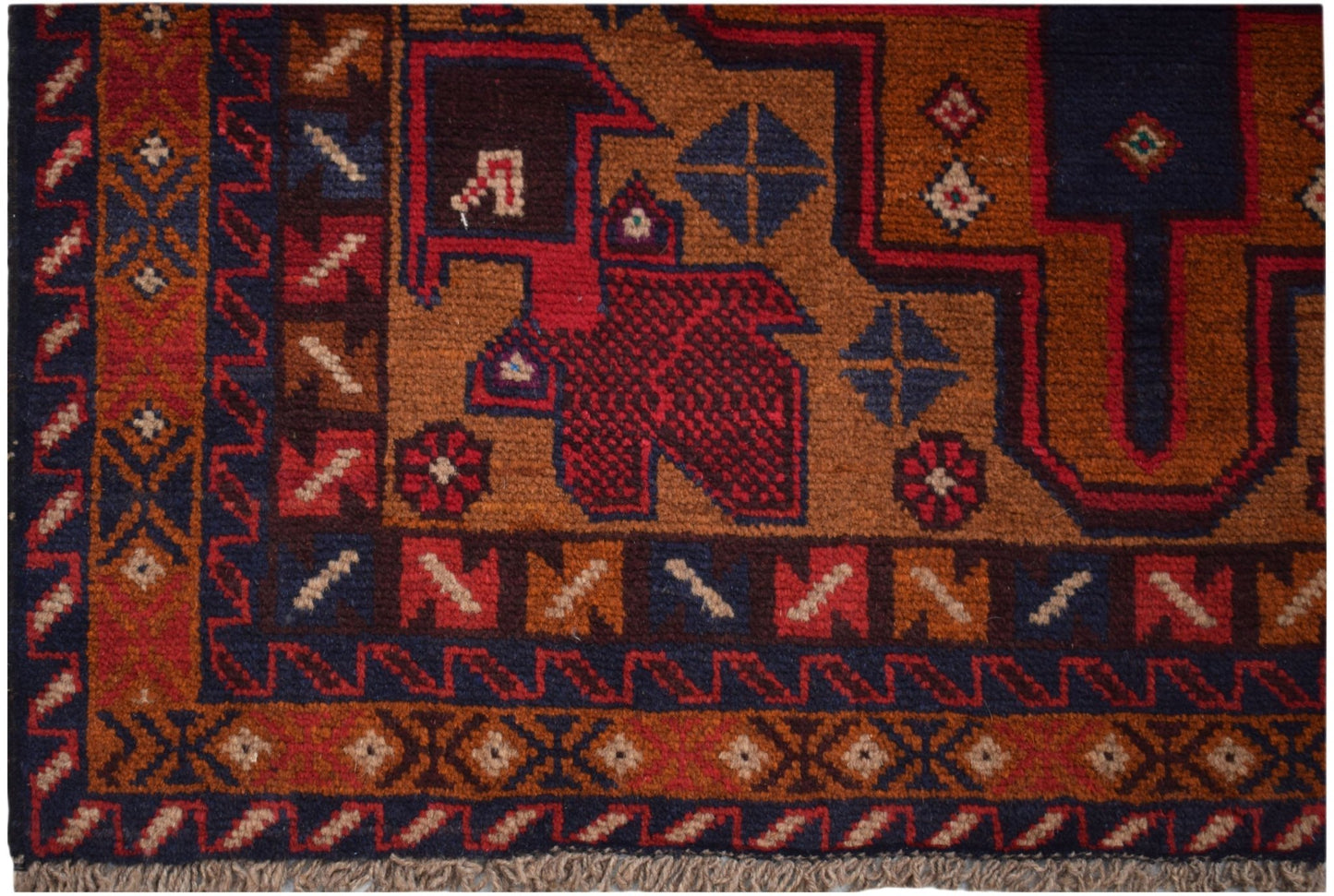 A handmade Afghan Baluch rug featuring geometric tribal patterns in deep red, brown, and blue tones.