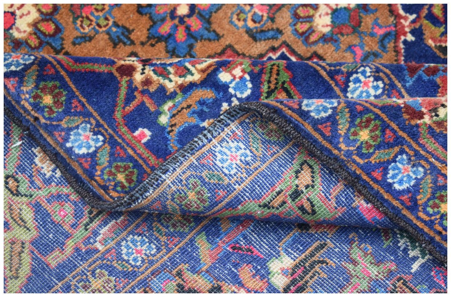 A vintage Afghan Baluch rug featuring intricate floral patterns in deep blue, brown, and red tones.