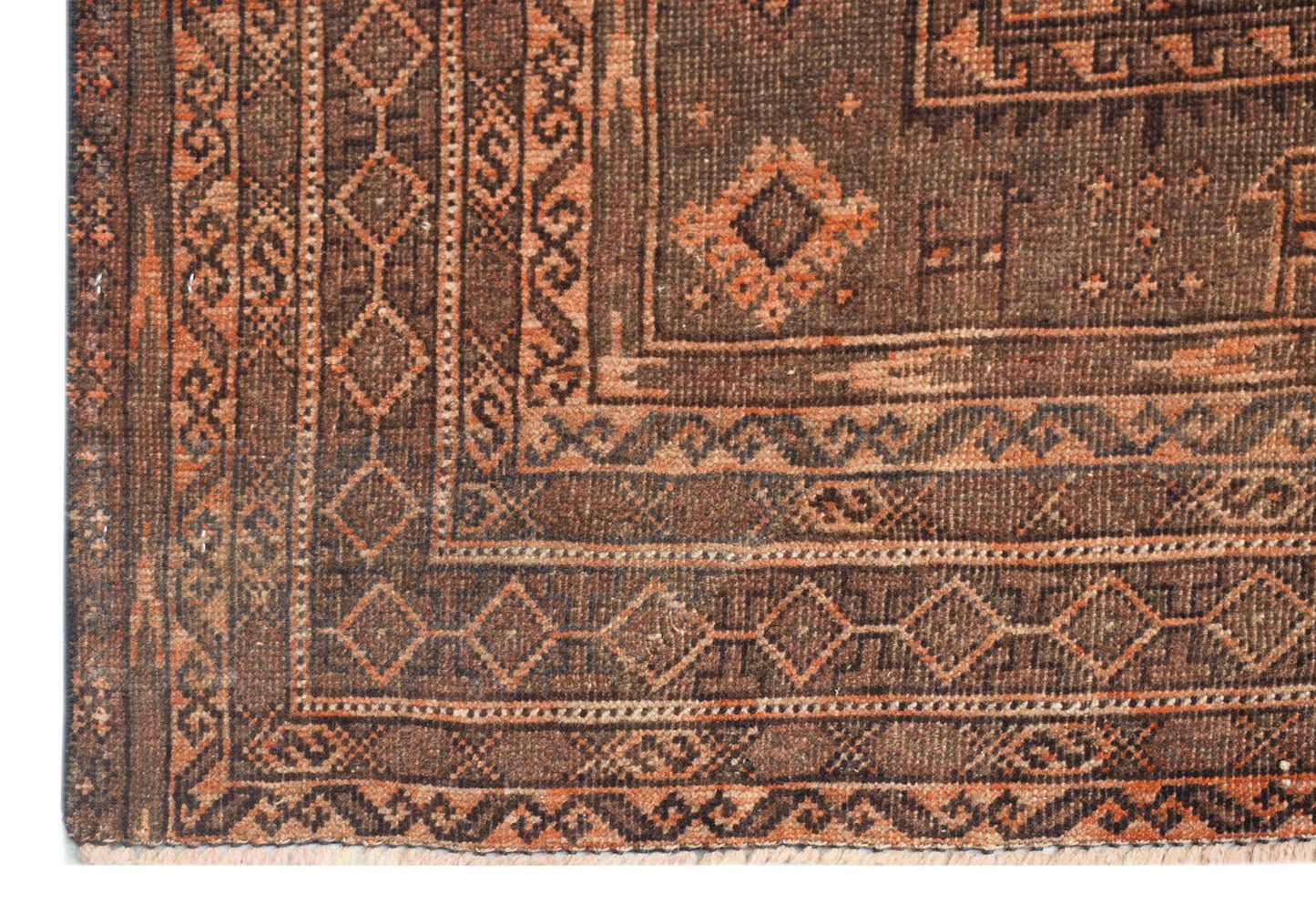A handmade Afghan Baluch rug featuring geometric patterns in shades of brown and burnt orange.