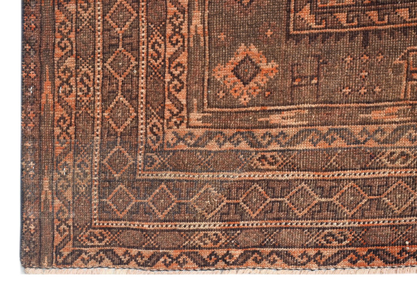 A handmade Afghan Baluch rug featuring geometric patterns in shades of brown and burnt orange.