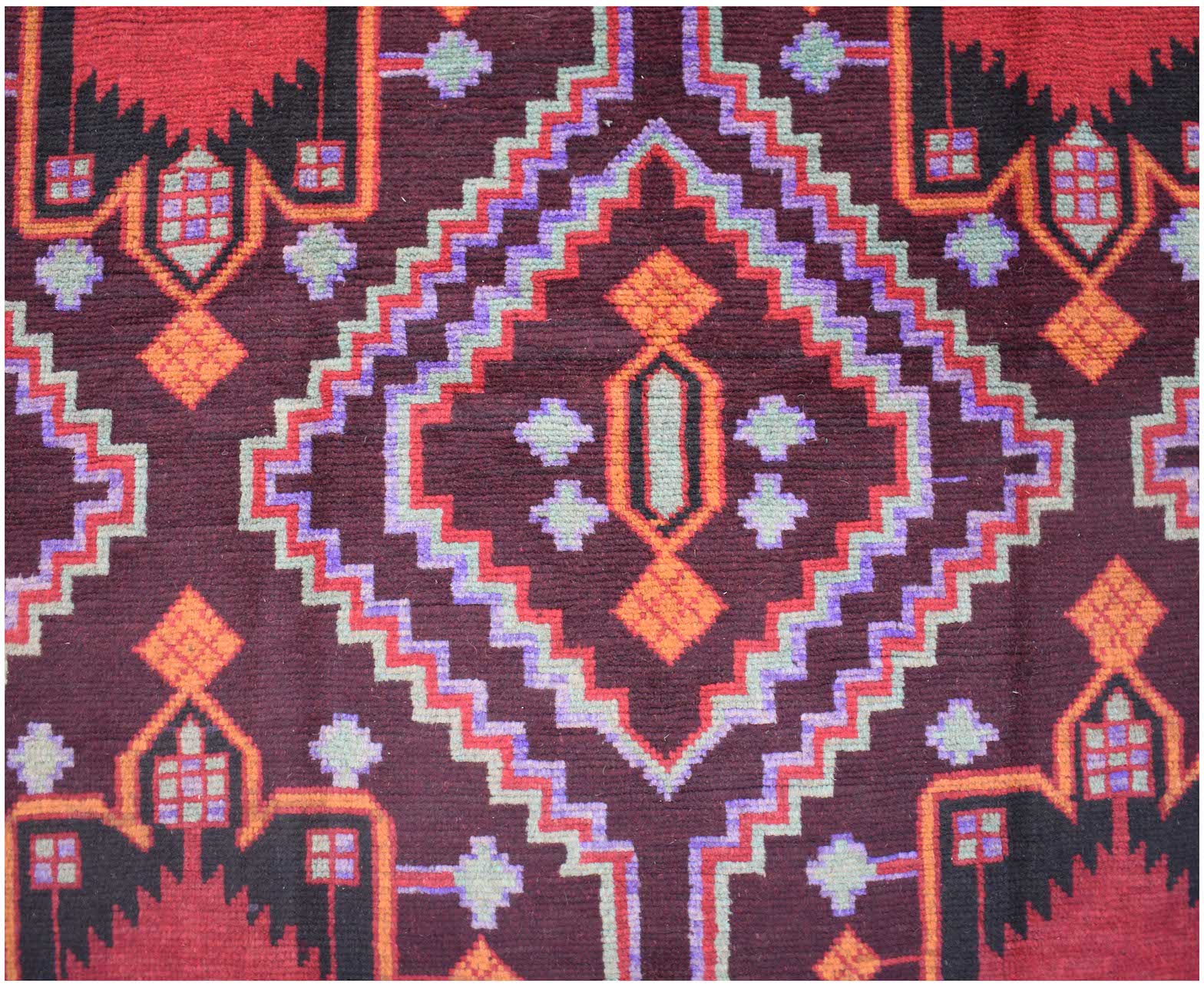 Handmade Afghan Pashm rug featuring a geometric diamond pattern in dark red, brown, and blue tones.