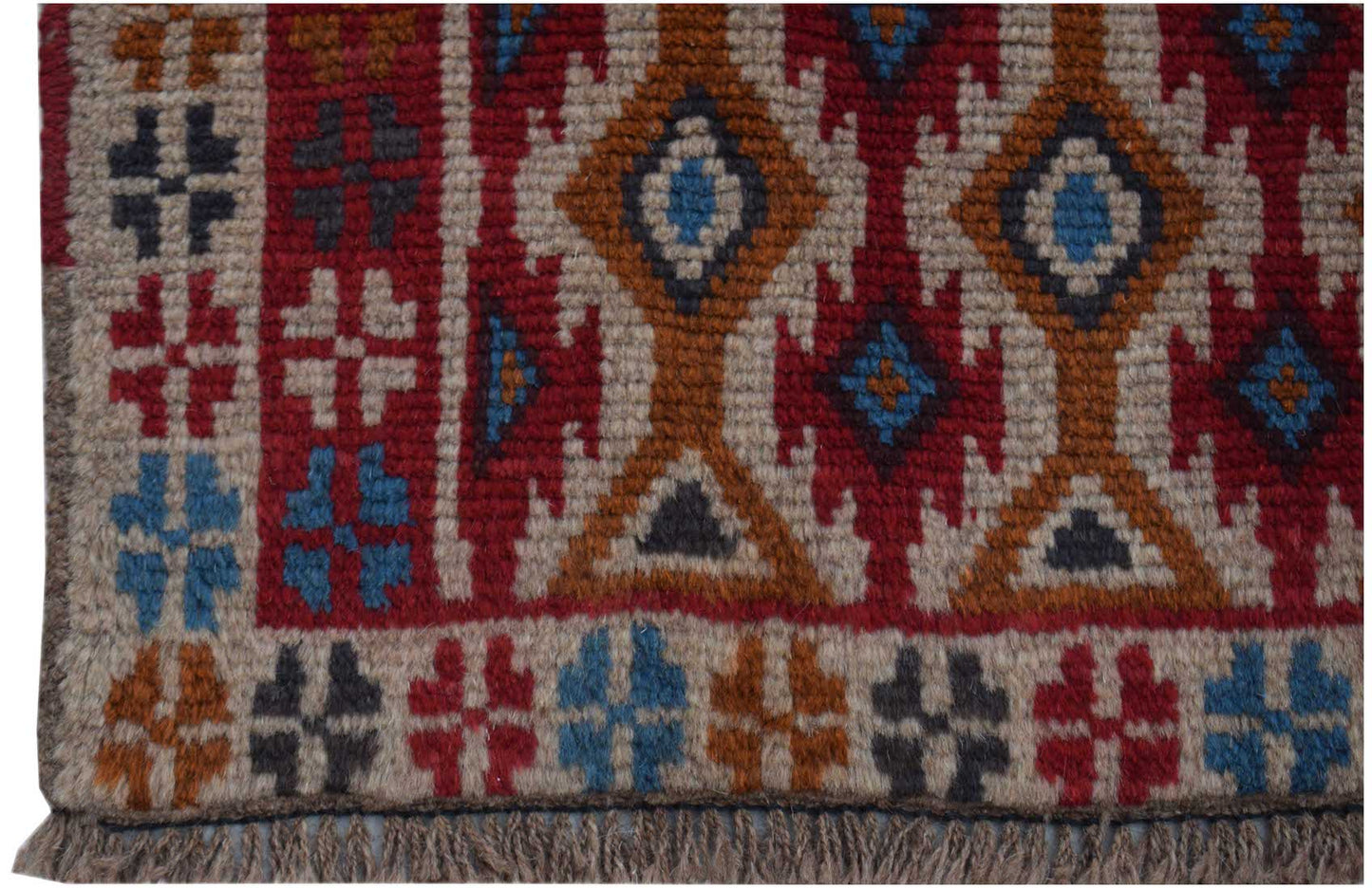 Handmade Afghan Pashm rug featuring a geometric tribal pattern in red, blue, and ivory wool.
