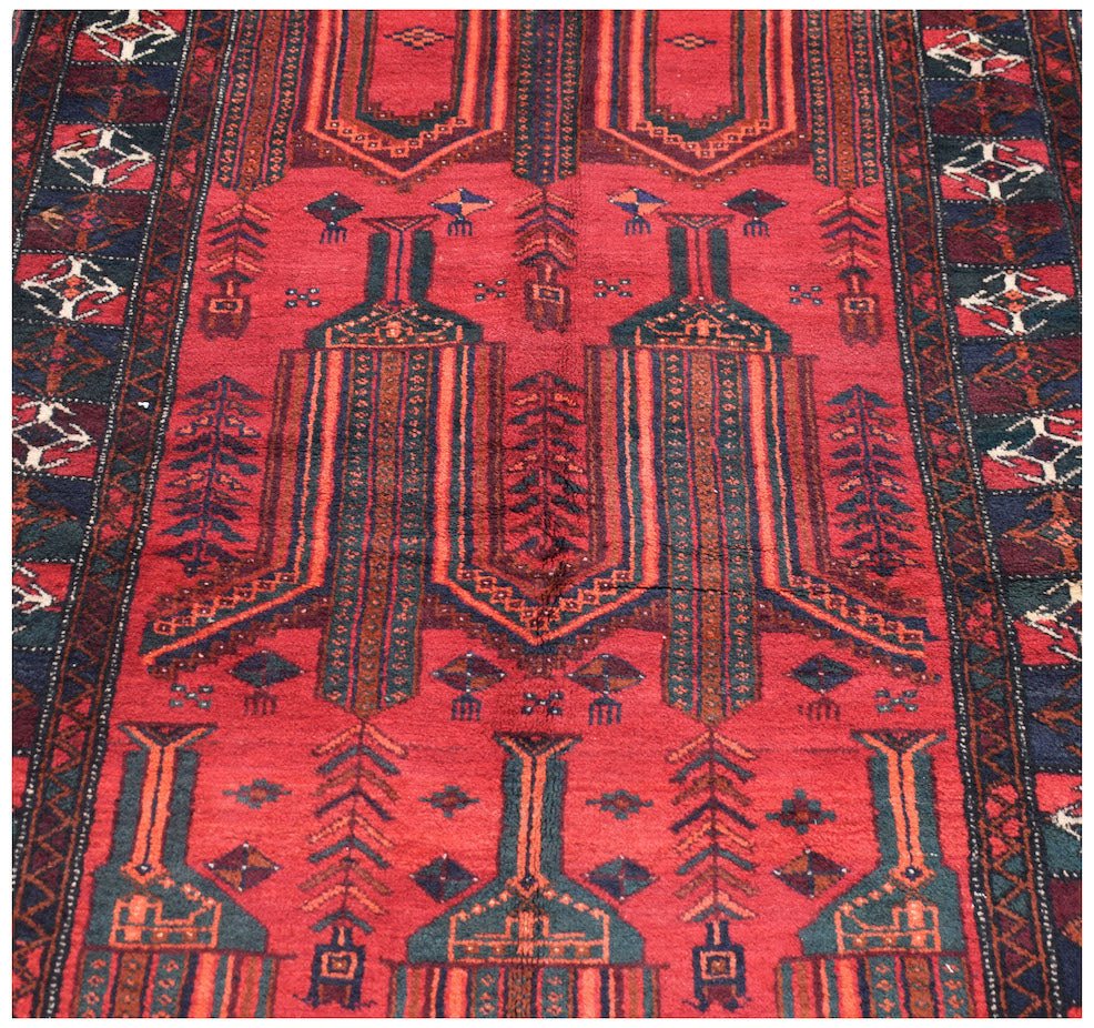 A vintage Afghan Baluch rug featuring a red field with repeating geometric tribal motifs.