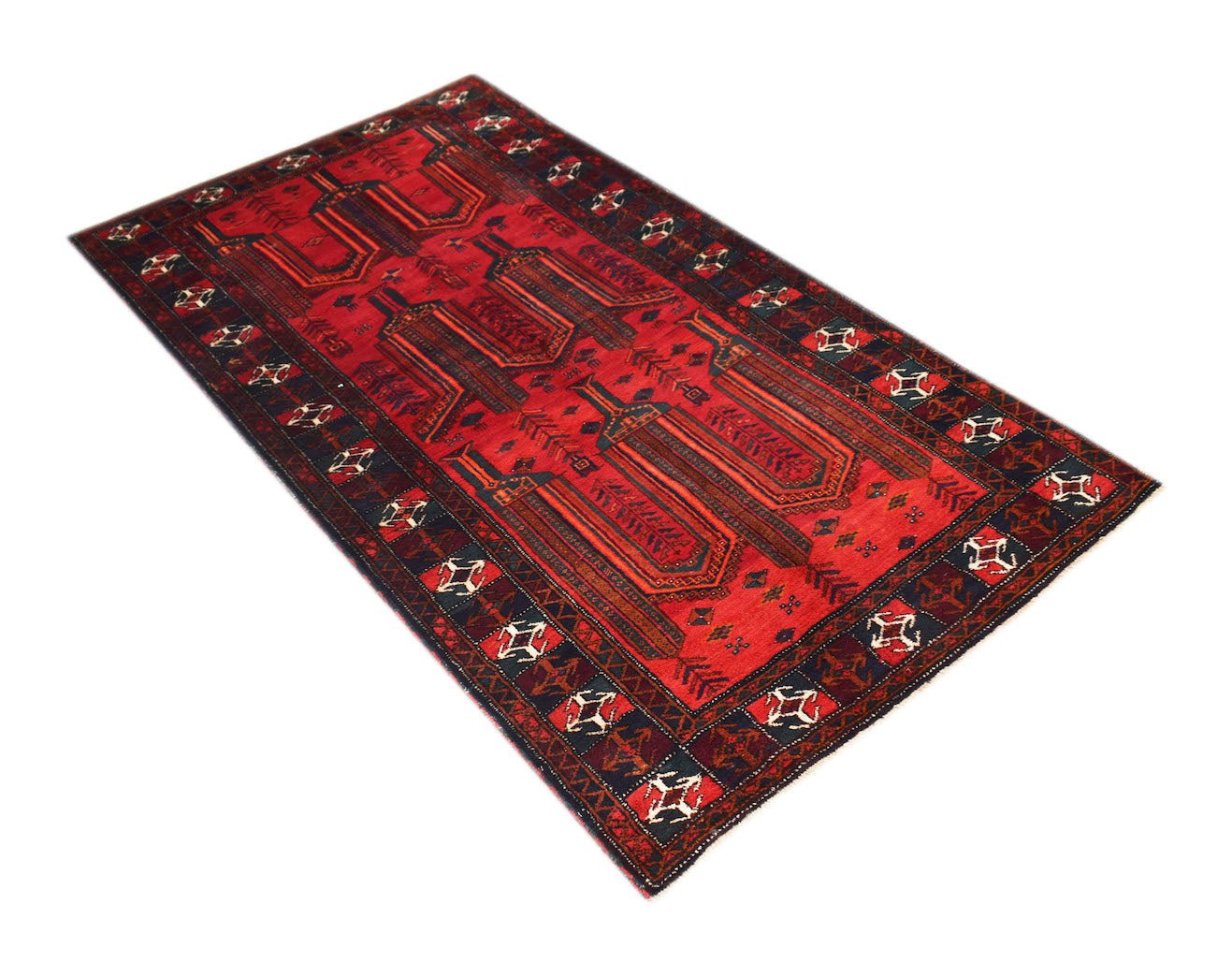 A vintage handmade Afghan Baluch rug featuring a geometric red field and dark patterned borders.
