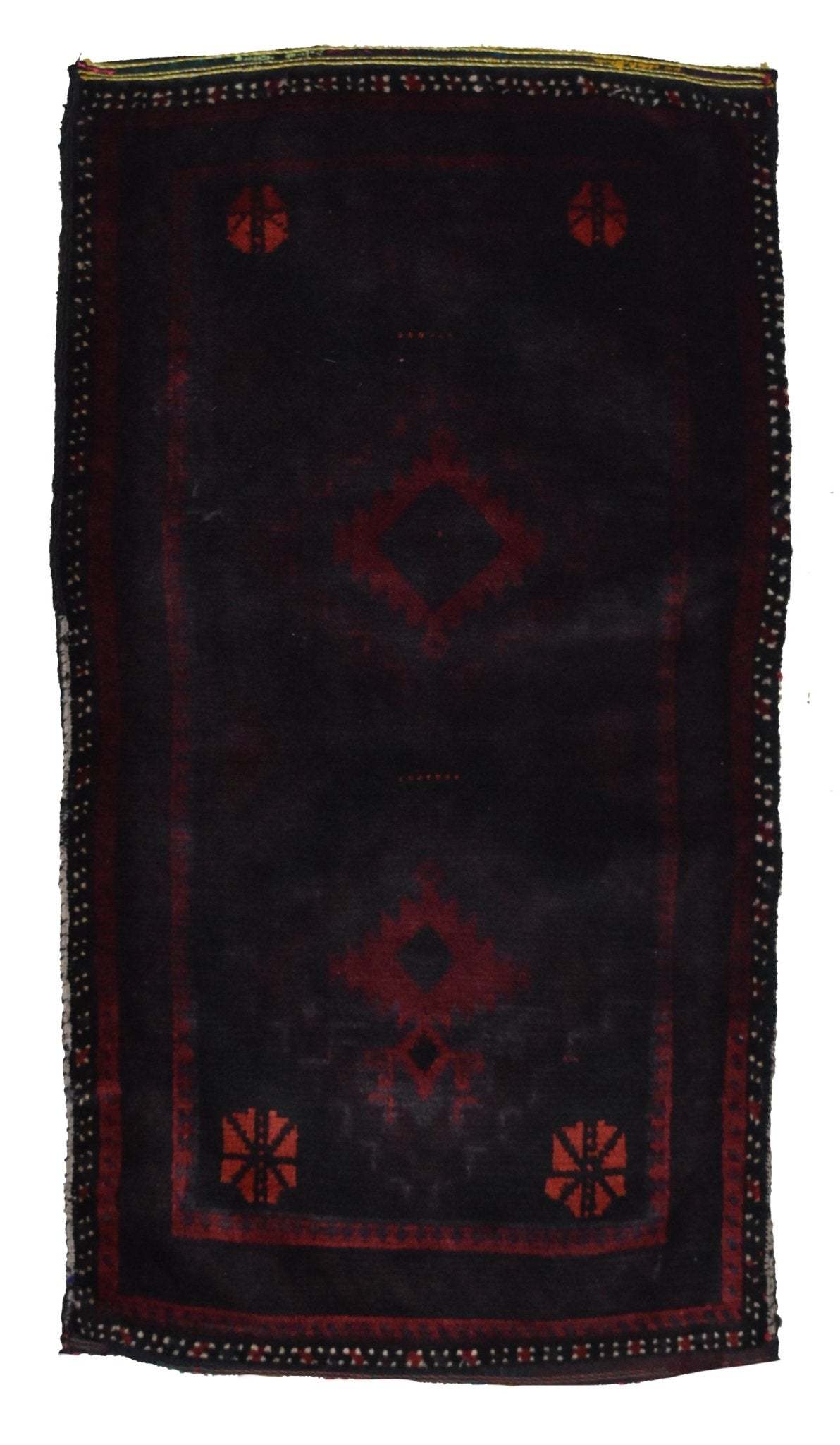 A handmade vintage Afghan Baluch wool cushion featuring a dark field with red geometric motifs.