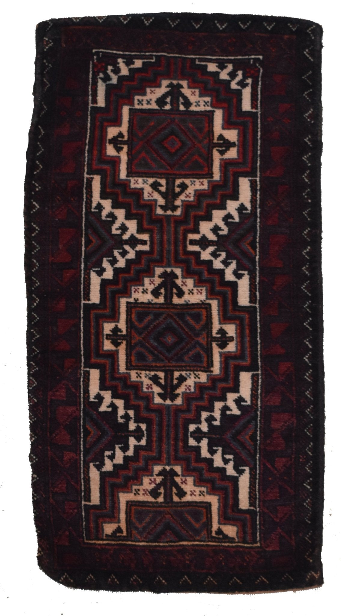 A vintage handmade Afghan Baluch wool cushion featuring a geometric tribal pattern in dark tones.