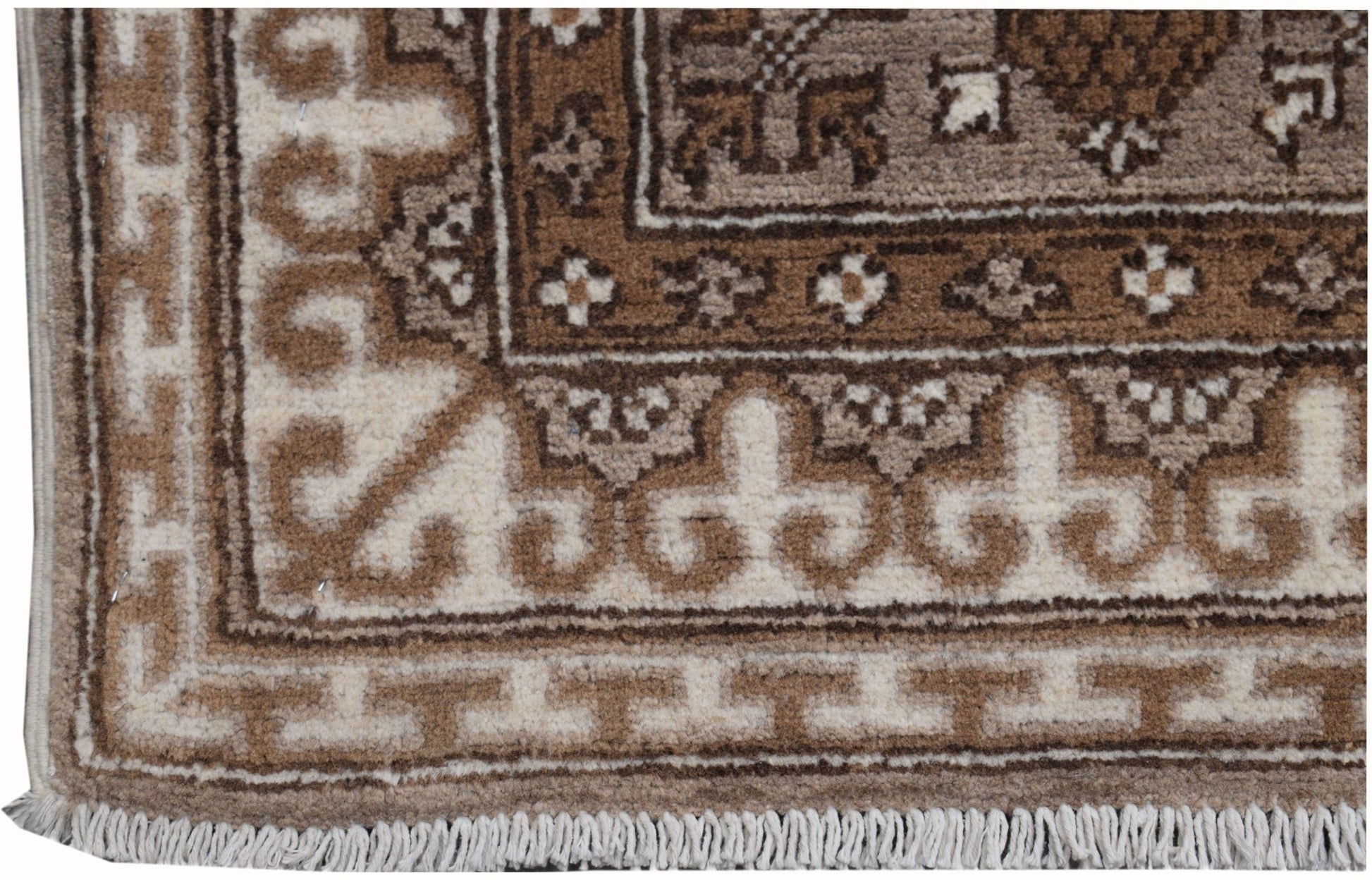 A corner view of a handmade Afghan Chobi runner featuring a geometric pattern in natural wool tones.