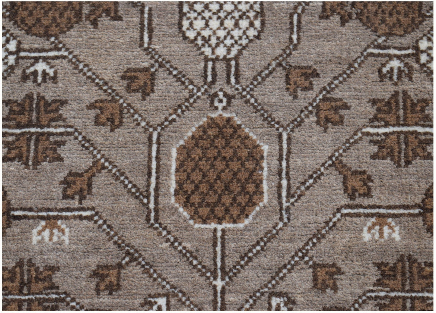 A close-up of an Afghan Chobi runner featuring a geometric pattern in shades of brown and cream.