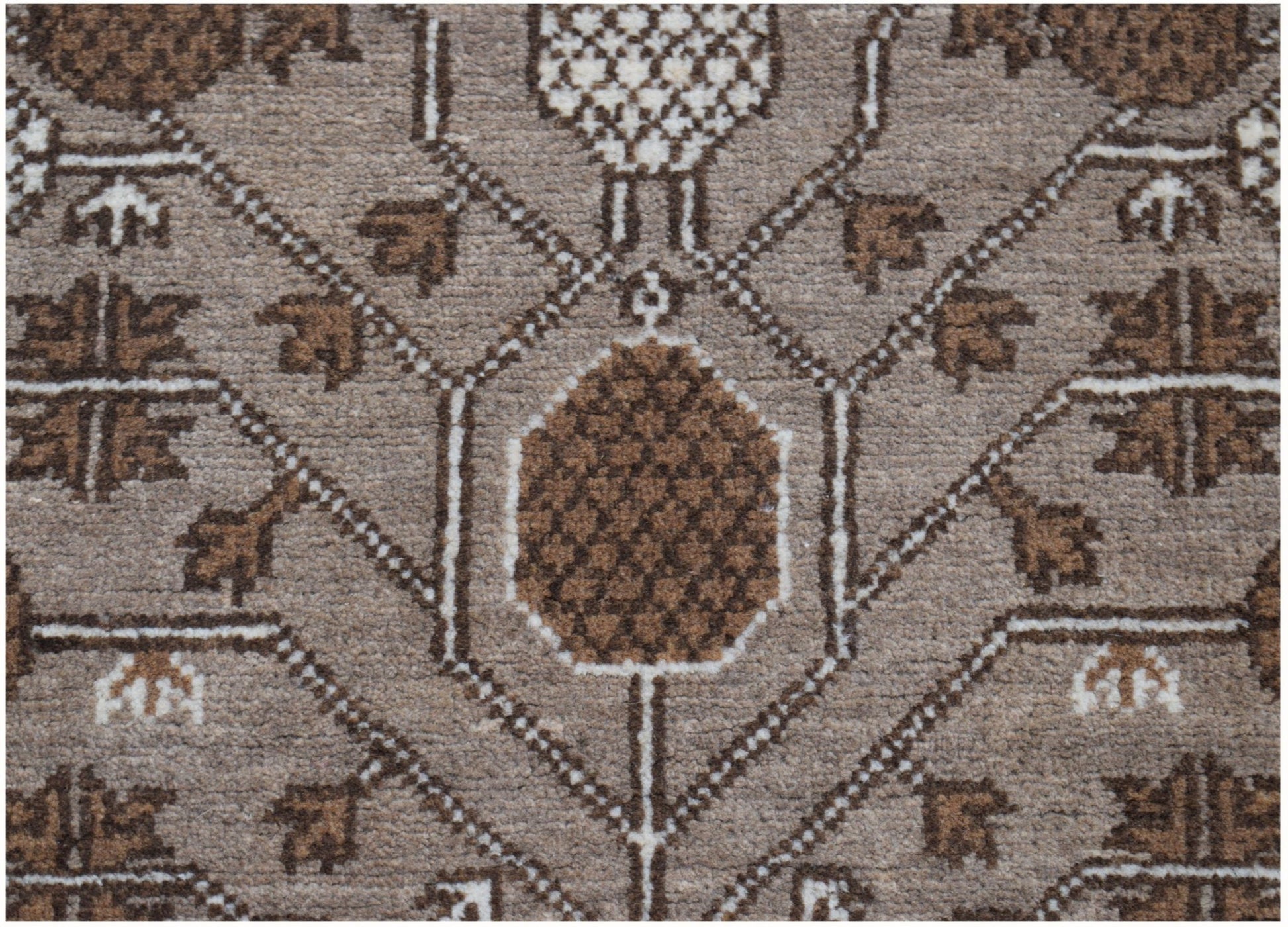 A close-up of an Afghan Chobi runner featuring a geometric pattern in shades of brown and cream.
