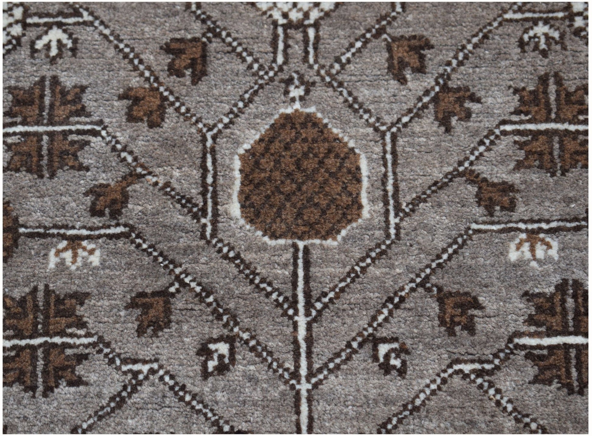 A handmade Afghan Chobi runner featuring a geometric brown and grey floral pattern.