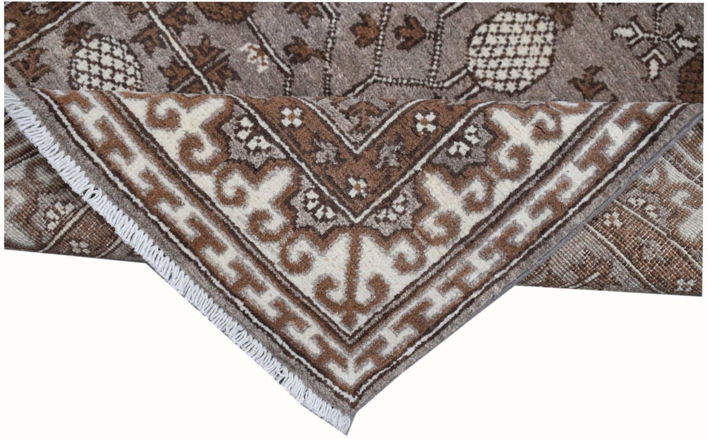 A handmade Afghan Chobi runner with a brown and cream geometric Khotan pattern and fringe.