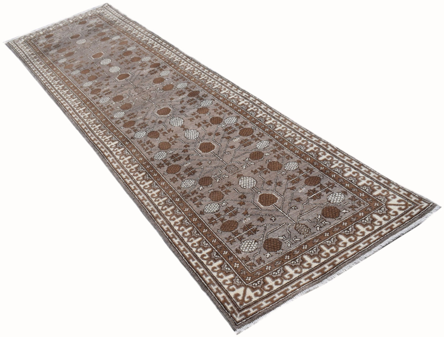 A handmade Afghan Chobi runner rug featuring a traditional Khotan pattern in shades of brown.