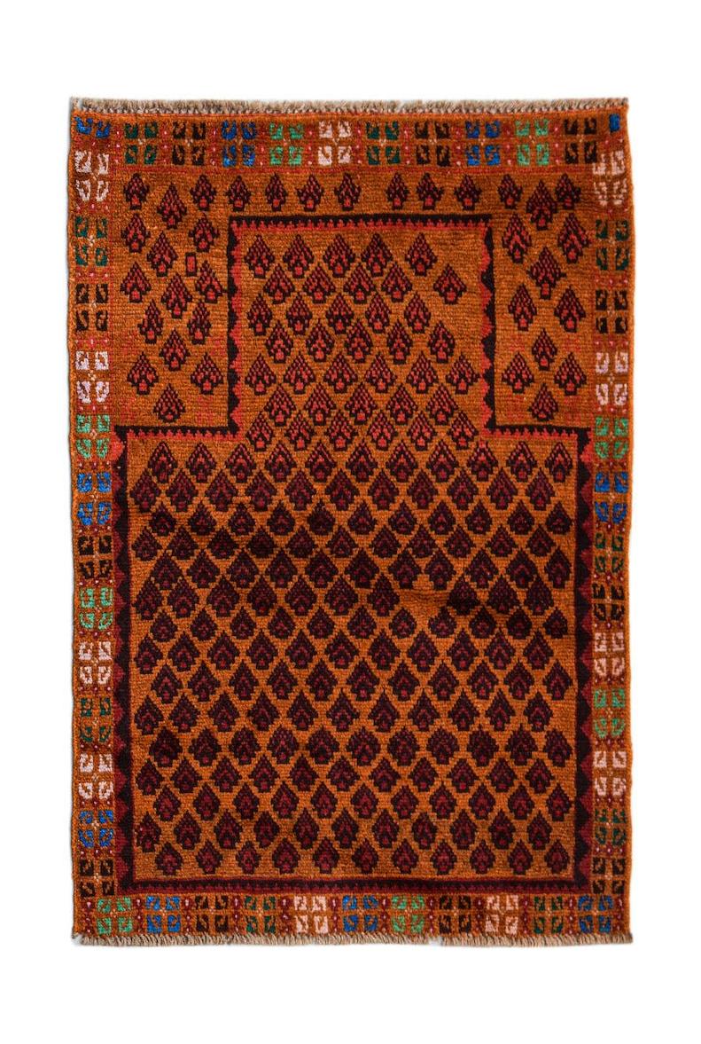 Handmade Afghan Pashm rug featuring a geometric pattern in shades of brown, red, and blue.