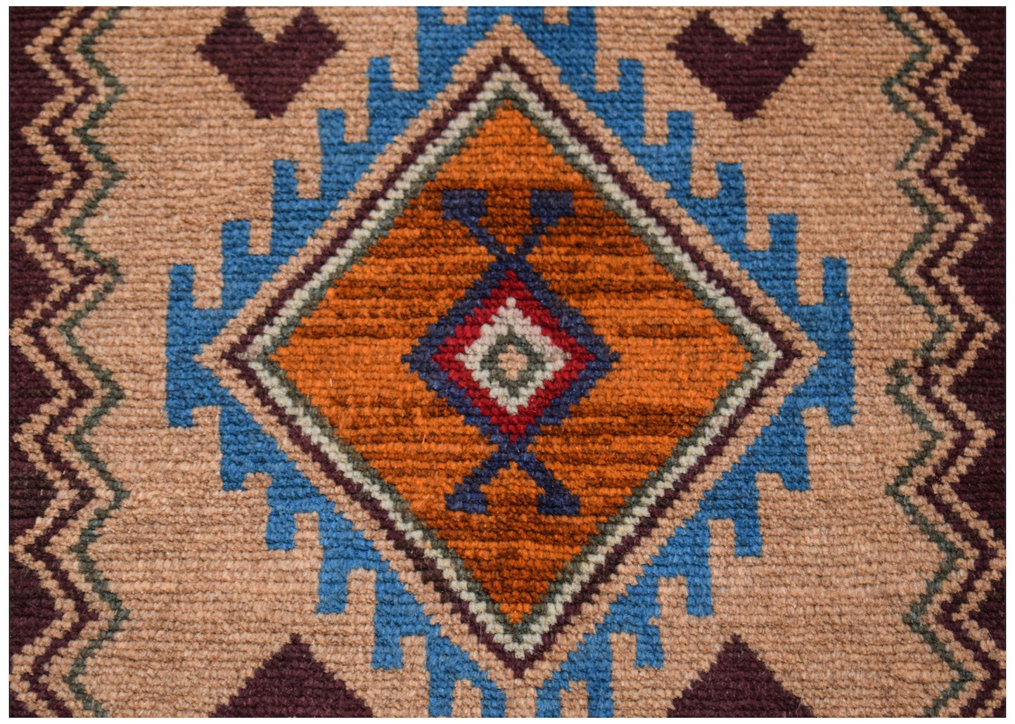 A handmade Afghan Pashm rug featuring a central diamond pattern in orange, blue, and dark red.