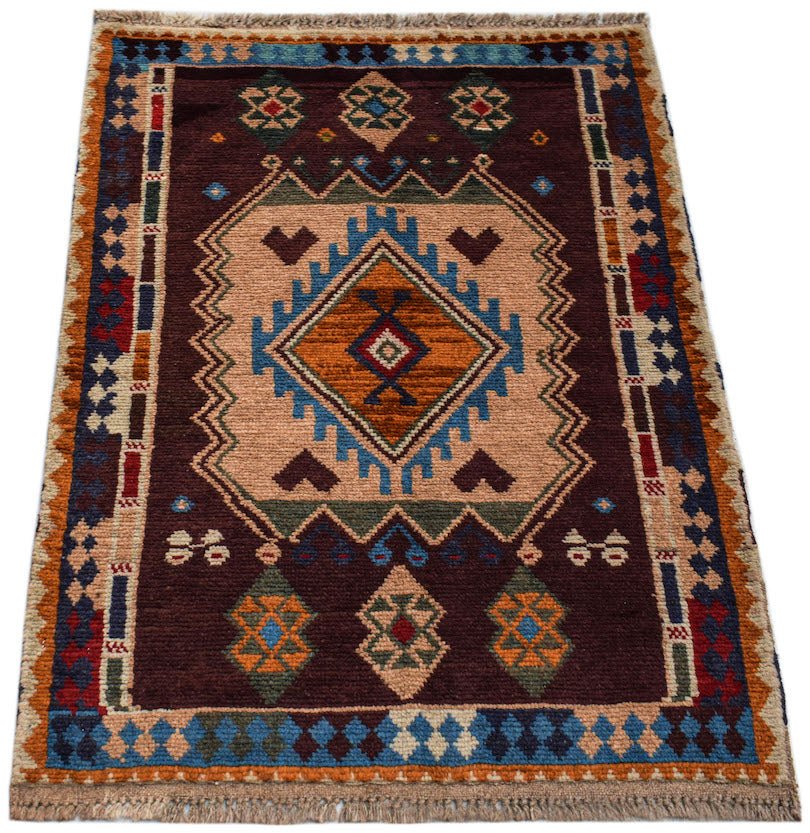 A handmade Afghan Pashm rug featuring a geometric tribal pattern in shades of brown, blue, and red.
