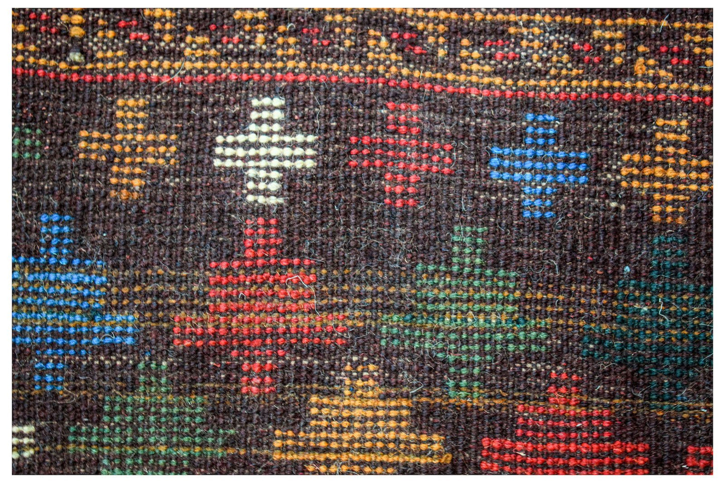 Handmade Afghan Pashm rug featuring a dark brown wool base with colorful geometric cross patterns.