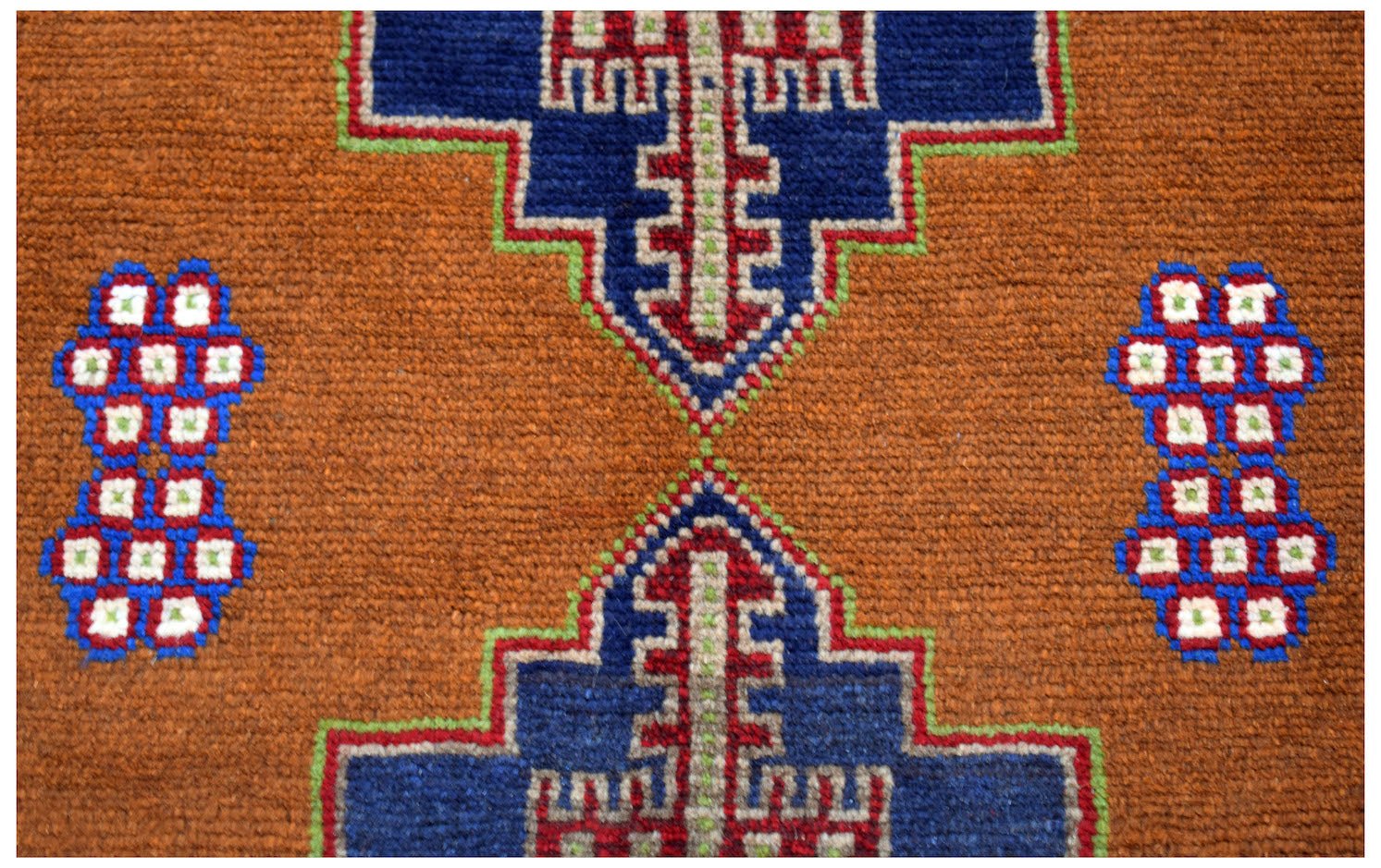 Handmade Afghan Pashm rug featuring geometric blue and red tribal motifs on a brown wool background.