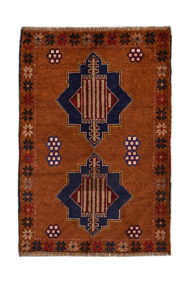 Handmade Afghan Pashm rug featuring two blue geometric medallions on a rust-colored wool field.