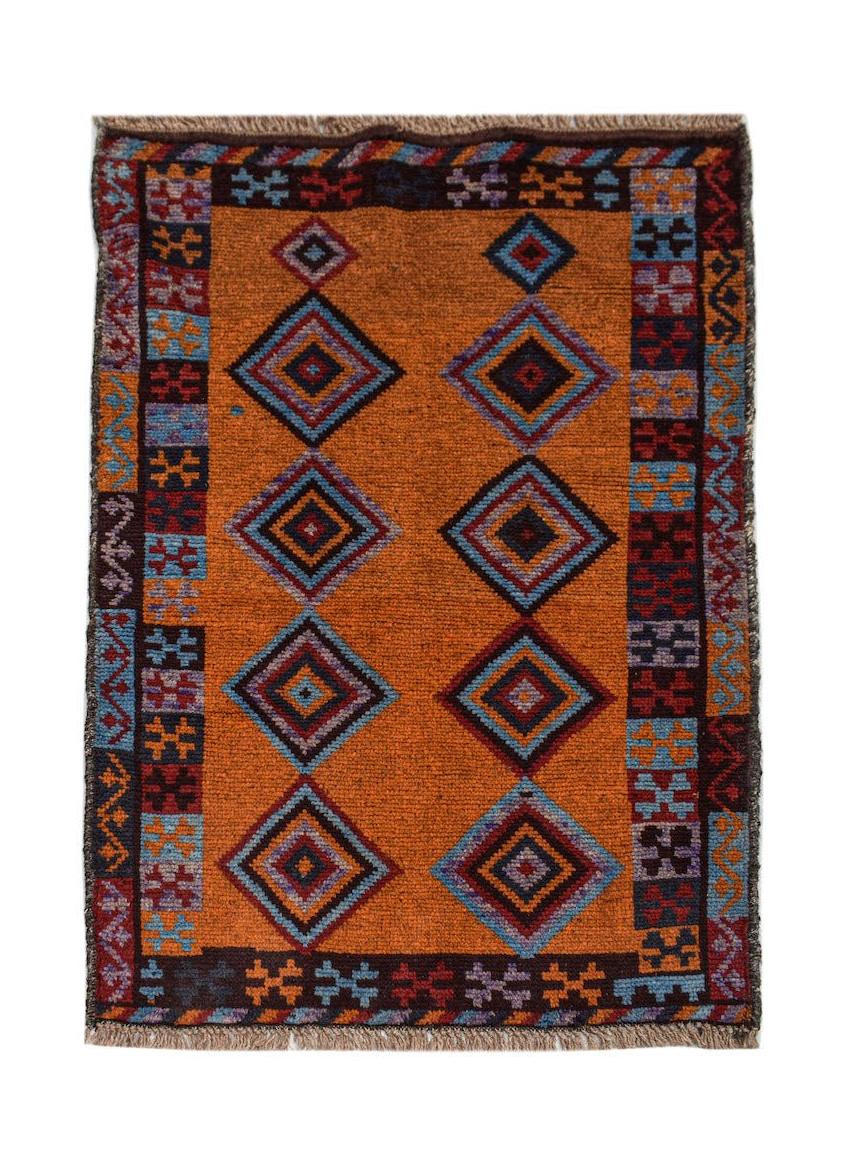 Handmade Afghan Pashm rug featuring geometric diamond patterns on an orange wool field.