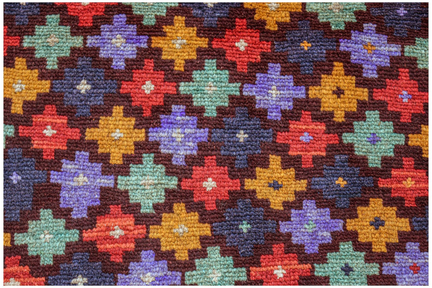 Handmade Afghan wool rug featuring a repeating geometric pattern in red, blue, yellow, and teal.