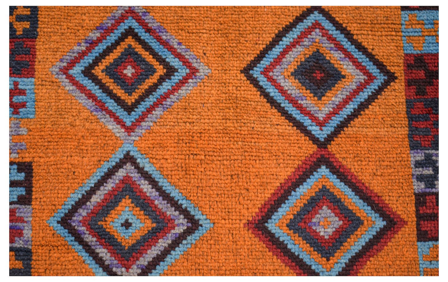 Handmade Afghan wool rug featuring a vibrant orange field with repeating geometric diamond motifs.