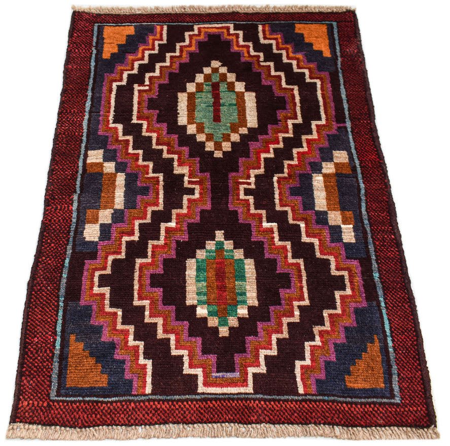 Handmade Afghan Pashm rug featuring a dark geometric pattern in red, brown, and blue tones.