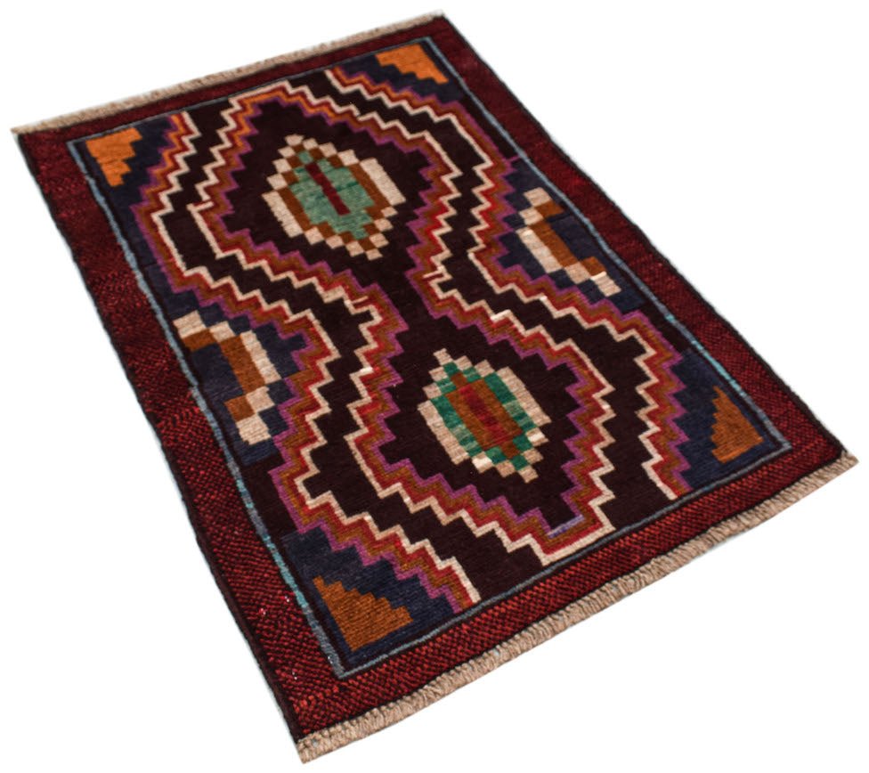 A handmade Afghan Pashm rug featuring a dark geometric pattern in red, brown, and blue tones.