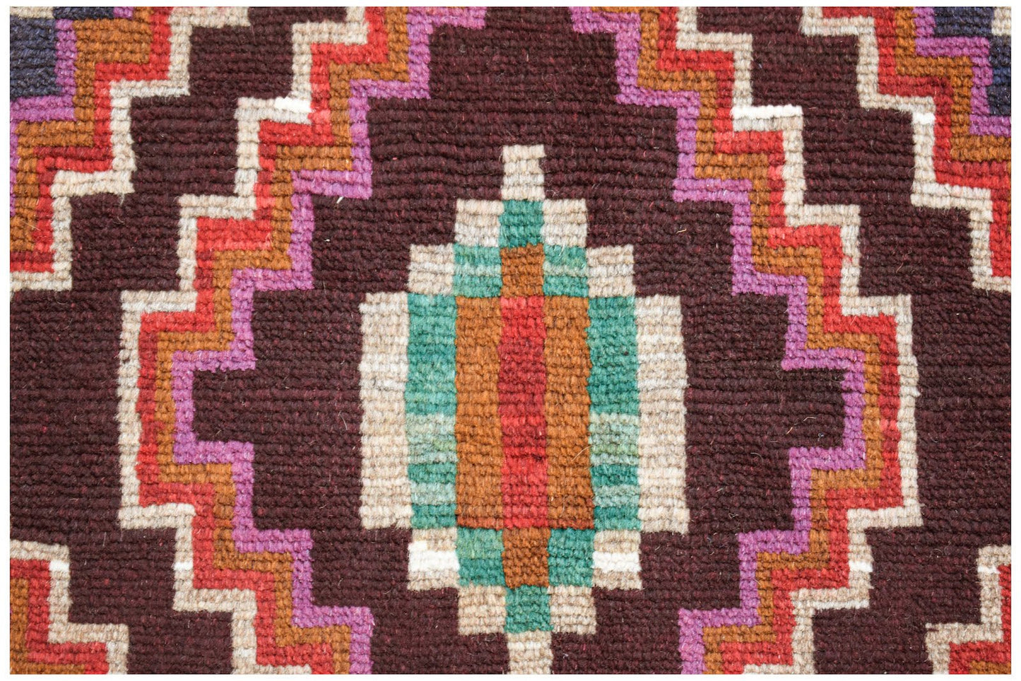 A handmade Afghan Pashm rug featuring a geometric diamond pattern in dark brown, red, and teal.